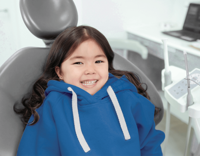 Kinderzahnheilkunde - lachendes Kind auf Behandlungsstuhl