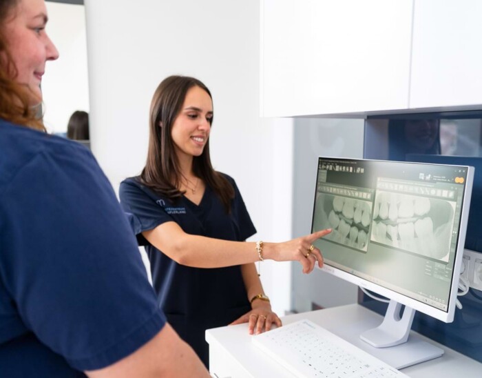 Zwei Mitarbeiterinnen betrachten R&ouml;ntgenaufnahmen an einem Bildschirm.