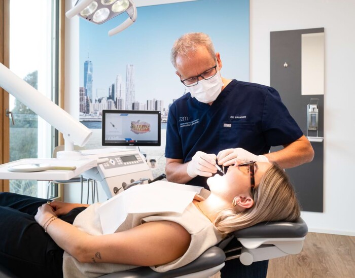 Dr. Brunner behandelt eine Patientin auf einer Liege.