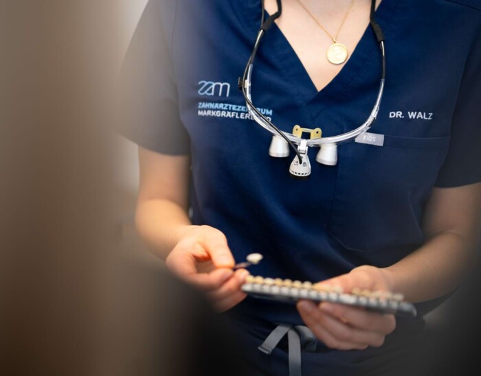 Eine Behandlerin zeigt Veneers.